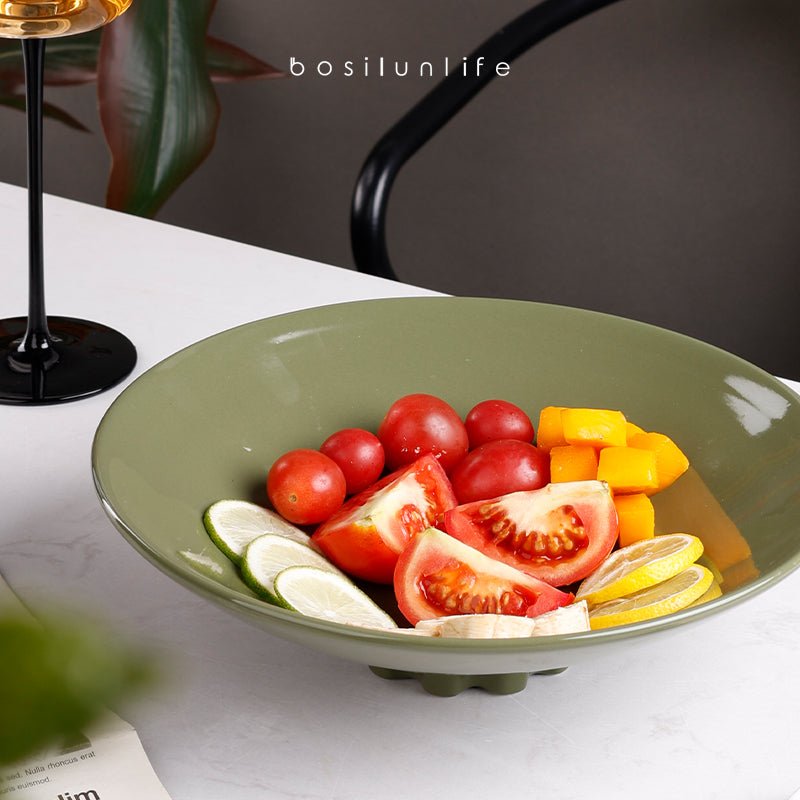 A green ceramic deep dish with fruit