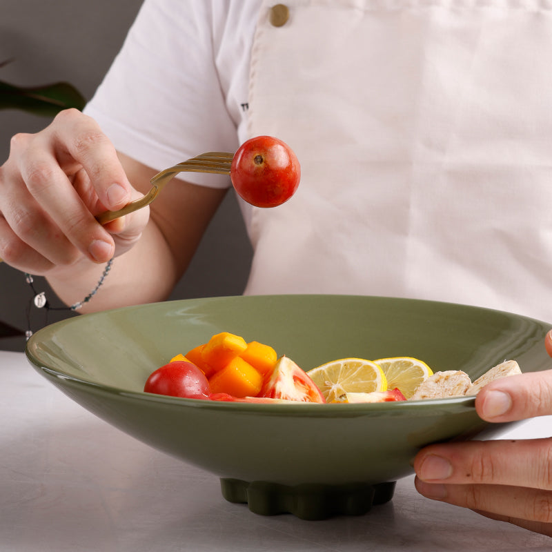 A green ceramic deep dish with fruit