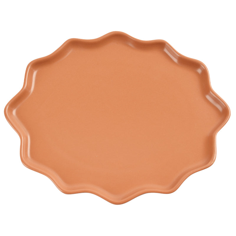 An irregularly shaped orange dinner plate